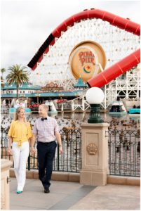 Man and Woman at Disneyland Engagement Picture session walking away from the Pixar Pier