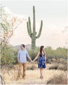 Phoenix Wedding Photographer photographs man and woman holding hands in front of a tall Saguaro cactus